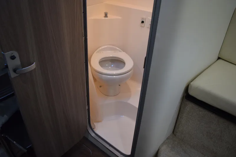 Slide: The Image of 2021 Regal 26 XO boat interior bathroom with toilet and wooden door. - 144