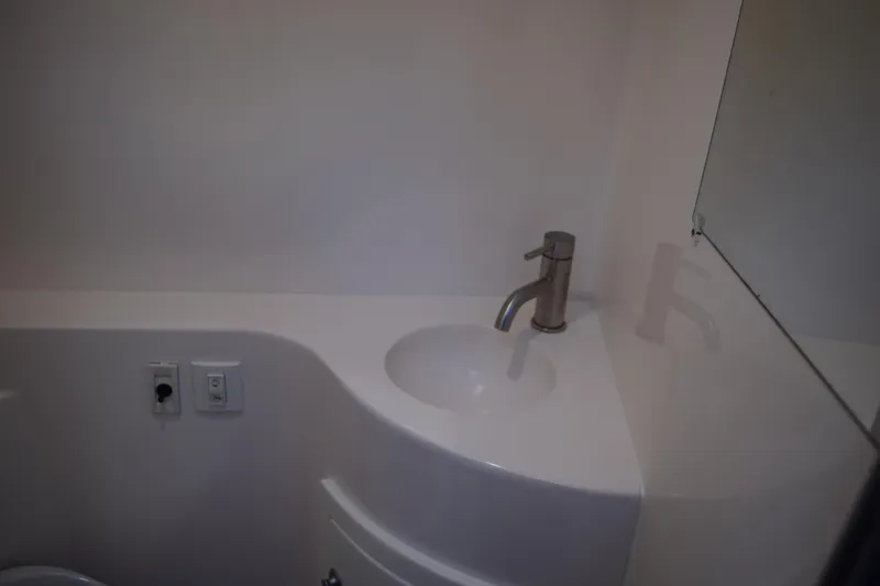 Slide: The Image of 2021 Regal 26 XO boat bathroom sink with modern faucet and mirror. - 148