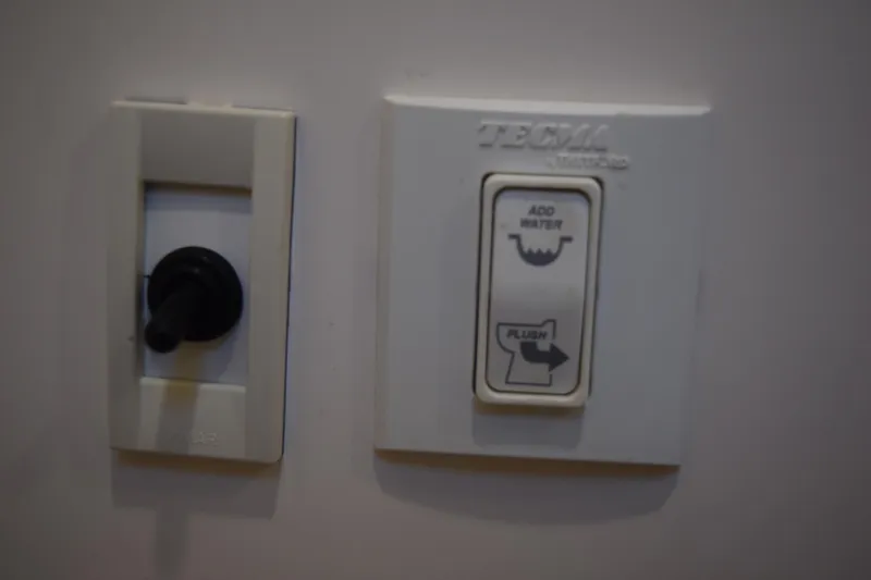Slide: The Image of Control panel with switches for water and flush on a 2021 Regal 26 XO boat. - 152