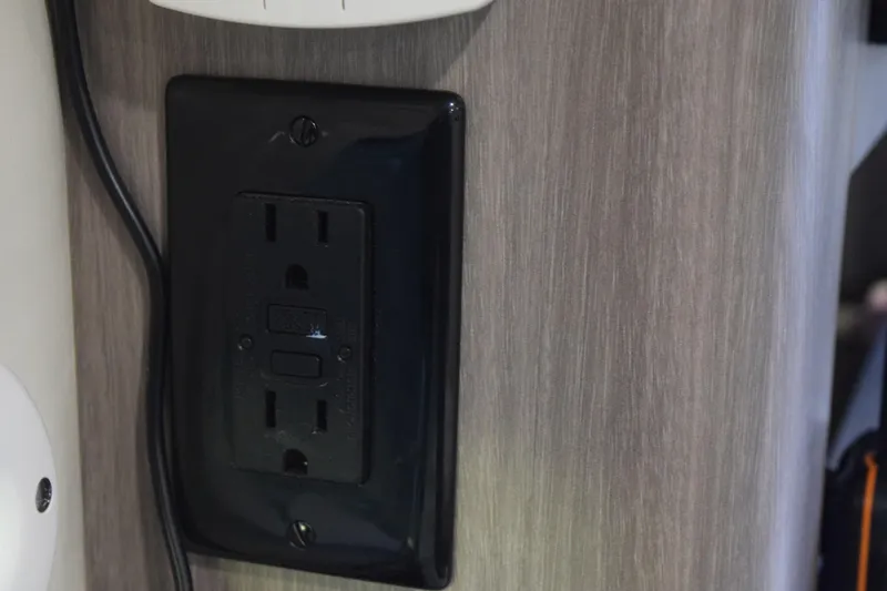 Slide: The Image of 2021 Regal 26 XO interior showing a black electrical outlet on a wooden panel. - 169