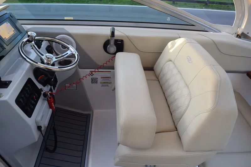 Slide: The Image of 2021 Regal 26 XO boat interior with steering wheel and beige seating. - 171