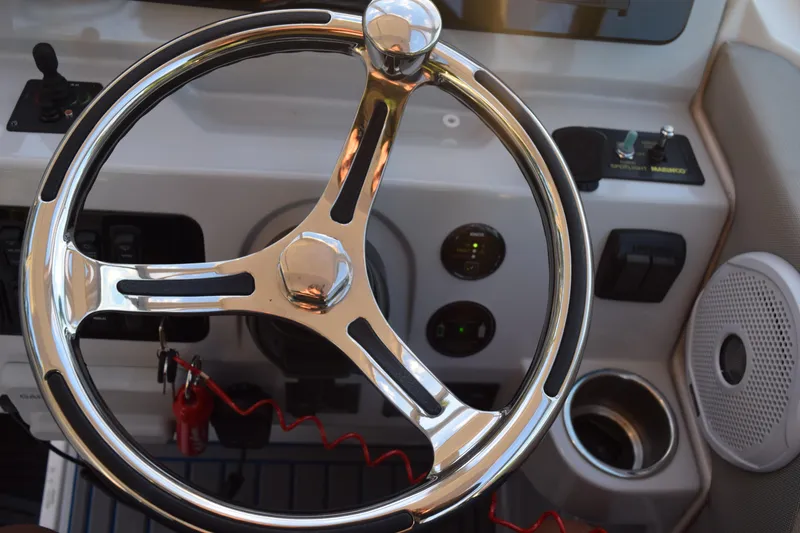 Slide: The Image of Steering wheel of 2021 Regal 26 XO boat with control panel and speaker. - 176