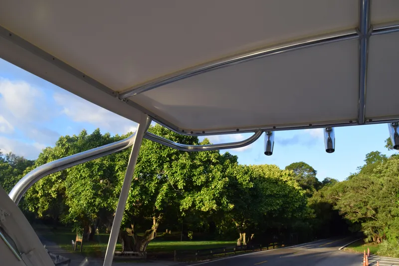 Slide: The Image of 2021 Regal 26 XO boat canopy with scenic green trees and road in background. - 183