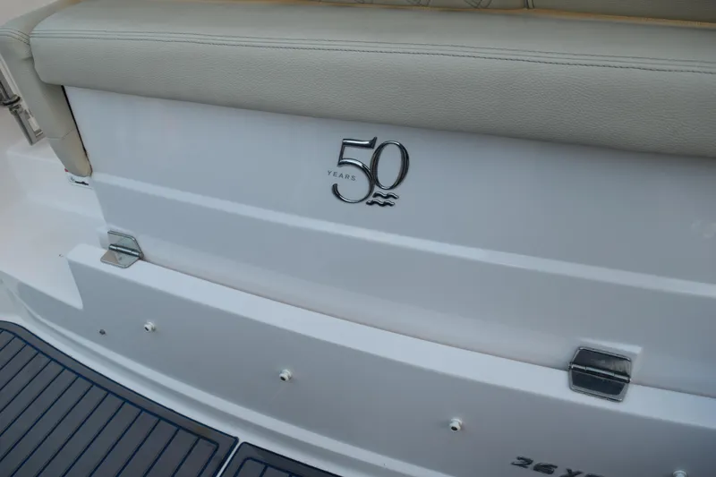 Slide: The Image of 2021 Regal 26 XO boat, 50th anniversary emblem, beige seating, and deck view. - 206