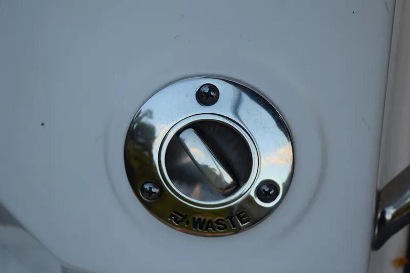 Slide: The Image of Waste outlet on 2021 Regal 26 XO boat, featuring a metallic cap. - 210
