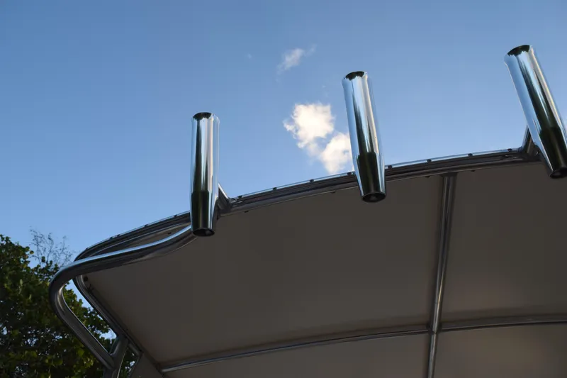 Slide: The Image of 2021 Regal 26 XO boat canopy with rod holders against blue sky. - 211