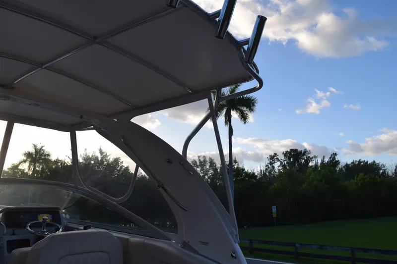 Slide: The Image of 2021 Regal 26 XO boat interior with canopy, scenic view of trees and sky. - 218