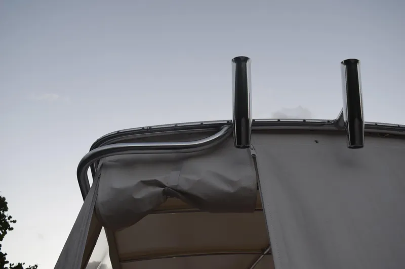 Slide: The Image of 2021 Regal 26 XO boat canopy and rod holders against sky. - 22