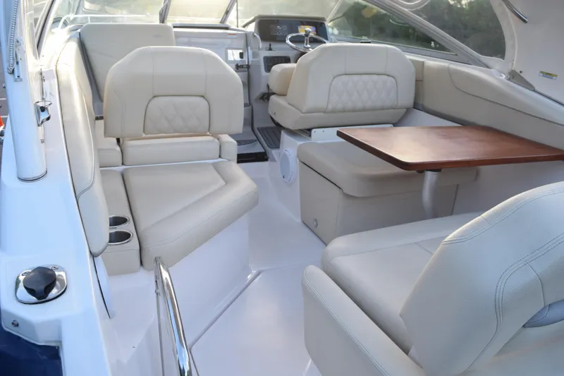 Slide: The Image of Luxurious interior of 2021 Regal 26 XO boat with beige seating and wooden table. - 220