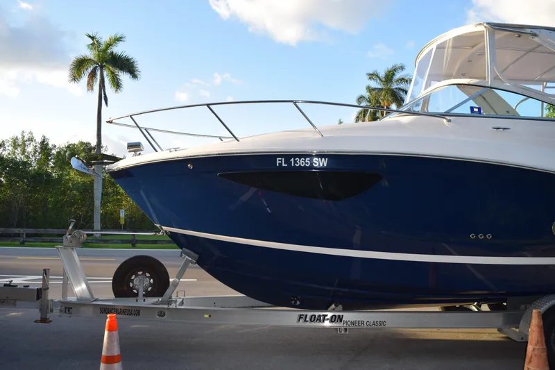 Slide: The Image of 2021 Regal 26 XO boat on trailer, palm trees in background, sunny day. - 232