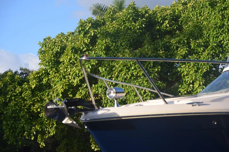 Slide: The Image of 2021 Regal 26 XO boat bow against lush green foliage background. - 236