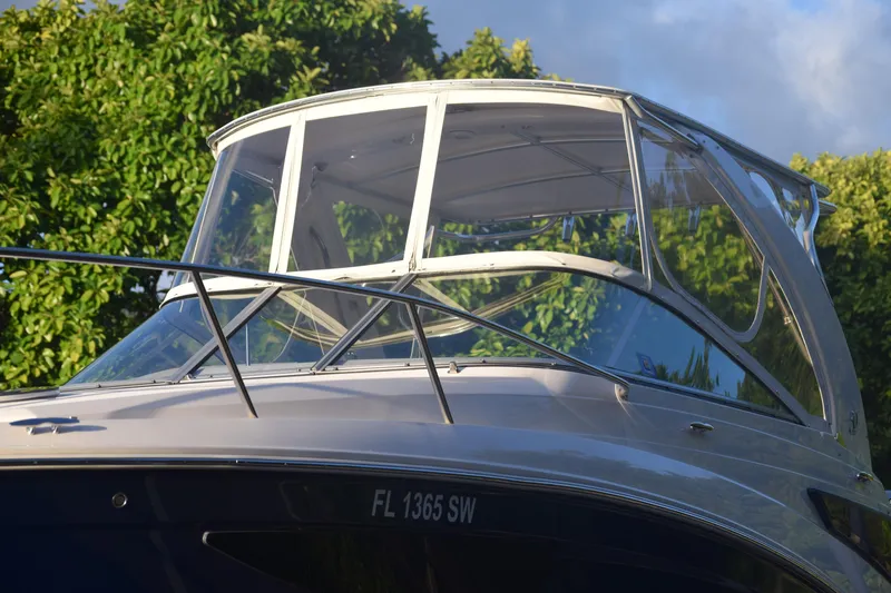 Slide: The Image of 2021 Regal 26 XO boat with sleek design and clear canopy, surrounded by greenery. - 237