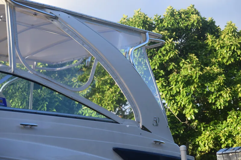 Slide: The Image of 2021 Regal 26 XO boat with sleek design against lush green foliage. - 238