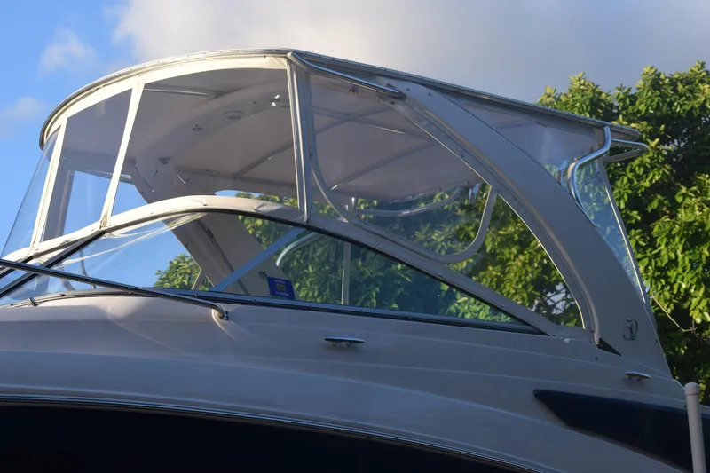 Slide: The Image of 2021 Regal 26 XO boat with clear canopy against blue sky and trees. - 239