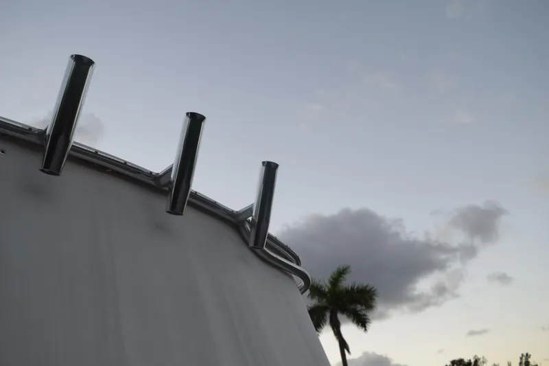 Slide: The Image of 2021 Regal 26 XO boat with rod holders against a cloudy sky backdrop. - 24