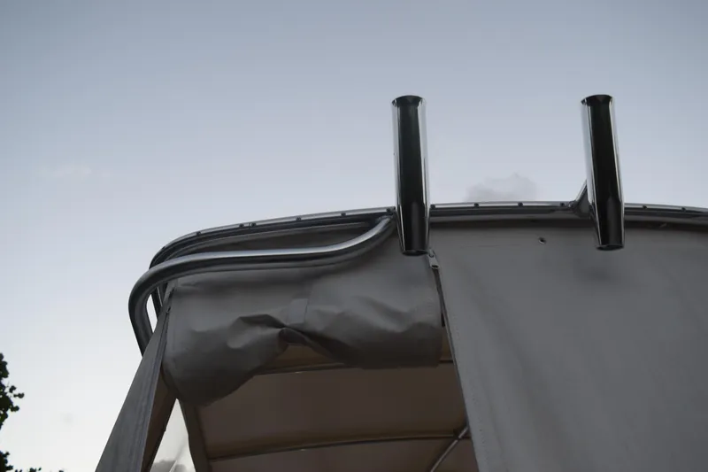 Slide: The Image of 2021 Regal 26 XO boat canopy and rod holders against a clear sky. - 25