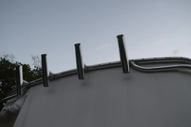 Slide: The Image of 2021 Regal 26 XO boat with stainless steel rod holders against a clear sky. - 31