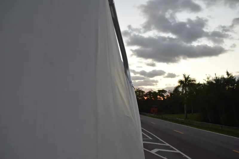 Slide: The Image of Covered 2021 Regal 26 XO boat on roadside at sunset with cloudy sky. - 32