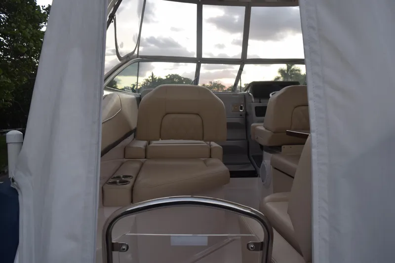 Slide: The Image of 2021 Regal 26 XO boat interior with beige seating and panoramic windows. - 44