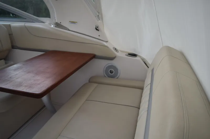 Slide: The Image of Interior of 2021 Regal 26 XO boat with beige seating and wooden table. - 53