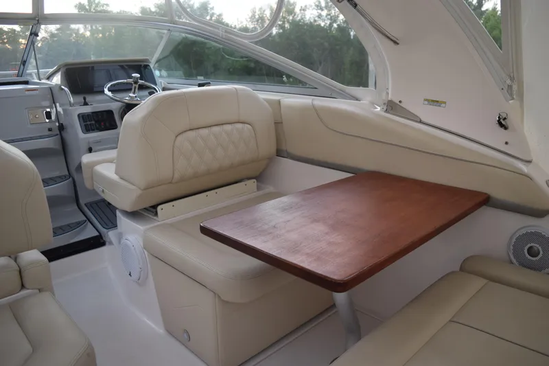 Slide: The Image of 2021 Regal 26 XO boat interior with beige seating and wooden table. - 56