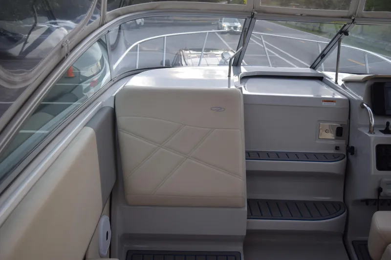 Slide: The Image of 2021 Regal 26 XO boat interior with beige seating and dashboard view. - 58
