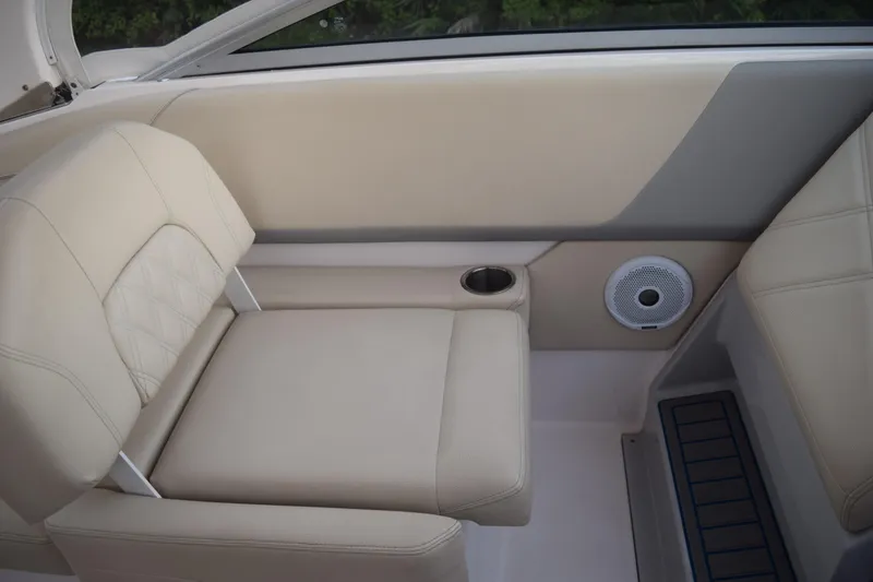 Slide: The Image of 2021 Regal 26 XO boat interior with beige seating, cup holder, and speaker. - 60