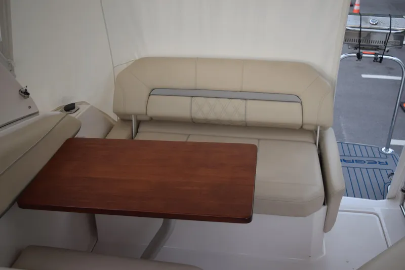 Slide: The Image of 2021 Regal 26 XO boat interior with beige seating and wooden table. - 70