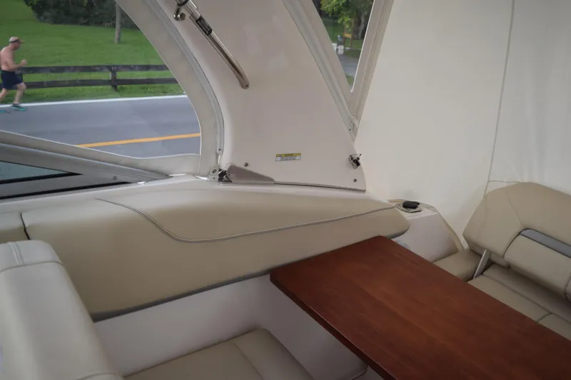 Slide: The Image of Interior of 2021 Regal 26 XO boat with beige seating and wooden table. - 71