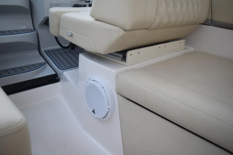 Slide: The Image of 2021 Regal 26 XO boat interior with beige seating and built-in speaker. - 77