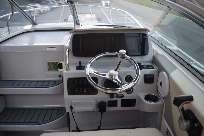 Slide: The Image of 2021 Regal 26 XO boat helm with steering wheel, controls, and navigation display. - 85