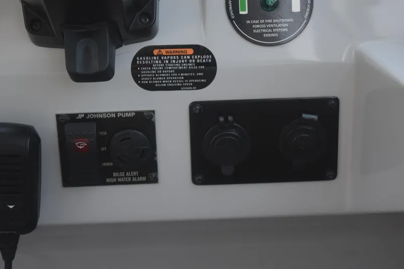 Slide: The Image of Control panel of a 2021 Regal 26 XO boat with warning labels and switches. - 89