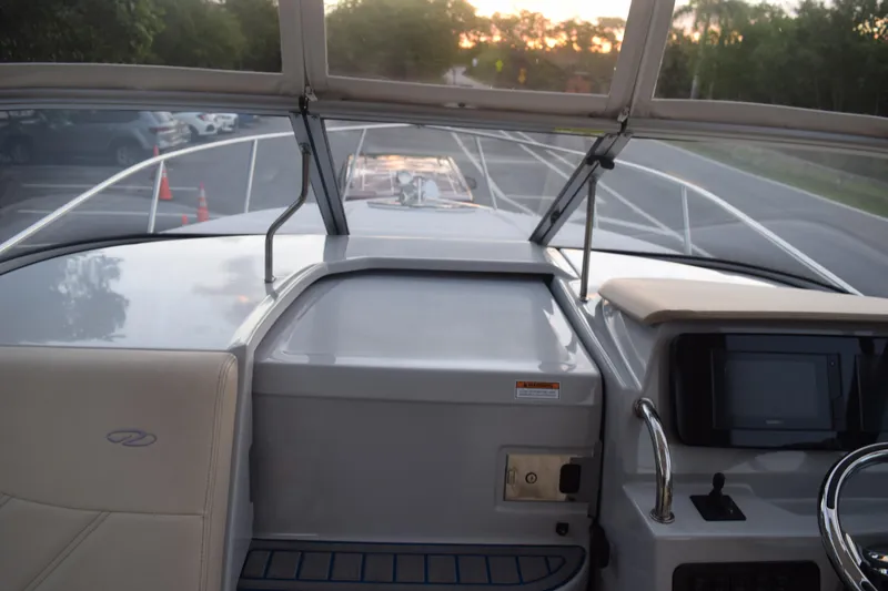 Slide: The Image of 2021 Regal 26 XO boat interior with dashboard and seating, parked at sunset. - 97