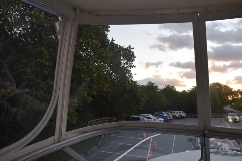 Slide: The Image of View from 2021 Regal 26 XO boat, overlooking parking lot and trees at sunset. - 99