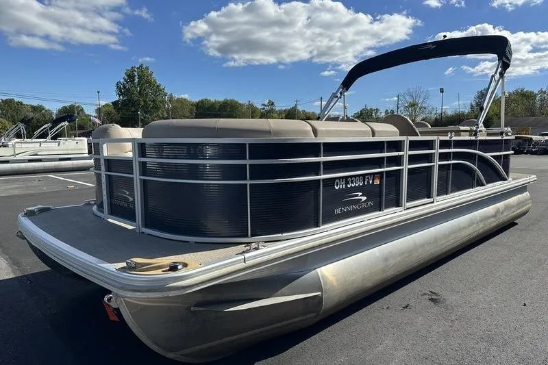 Slide: The Image of 2014 Bennington 24 SPDX pontoon boat parked under a clear blue sky. - 10