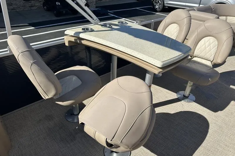 Slide: The Image of 2014 Bennington 24 SPDX boat interior with beige seating and a table. - 15