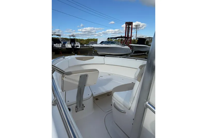 Slide: The Image of 2018 Robalo R222 Explorer boat interior with seating, parked outdoors under blue sky. - 2
