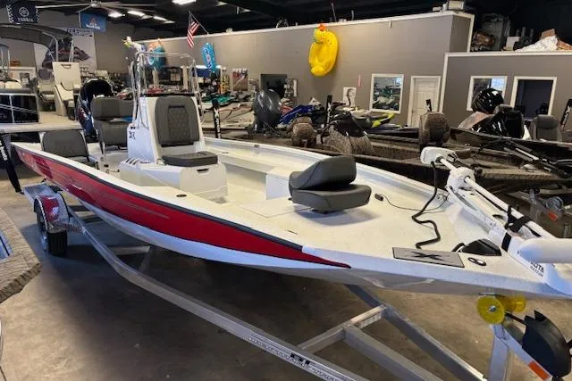 The Image of 2026 Xpress H22B Bay boat with red accents displayed in a showroom. - 1