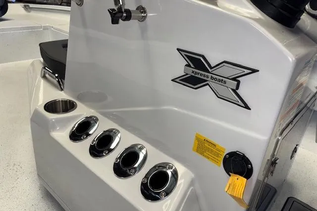 Slide: The Image of 2026 Xpress H22B Bay boat console with rod holders and logo detail. - 18