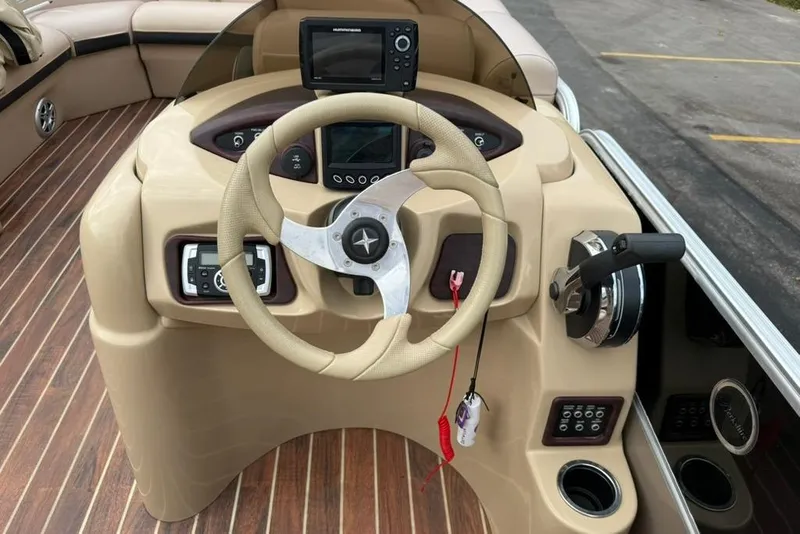 Slide: The Image of Steering console of 2016 Berkshire 230CL STS boat with modern controls and wood flooring. - 9