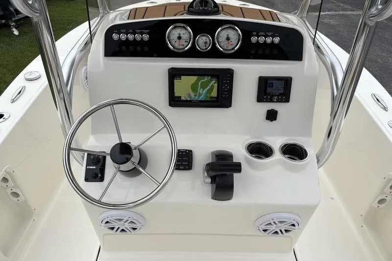 Slide: The Image of 2026 Pioneer Islander 180 boat dashboard with steering wheel, gauges, and navigation system. - 13