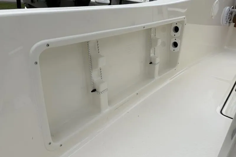 Slide: The Image of 2026 Pioneer Islander 180 boat interior detail, featuring storage compartment and clean white finish. - 17
