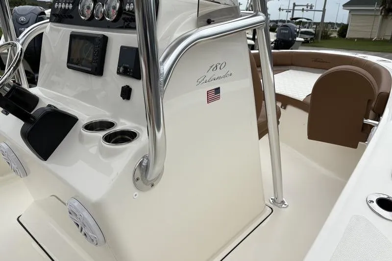 Slide: The Image of 2026 Pioneer Islander 180 boat interior with steering console and seating area. - 19