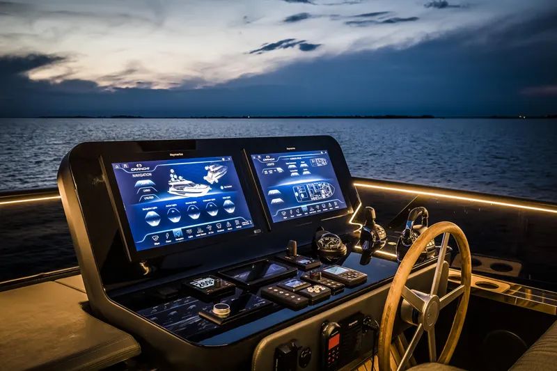 Slide: The Image of Helm of 2026 Cranchi Sessantasette 67 yacht with advanced navigation screens at sunset. - 15