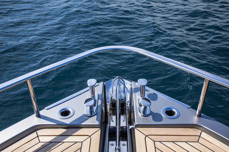 Slide: The Image of Bow of 2026 Cranchi Sessantasette 67 yacht with polished metal fittings on open water. - 26