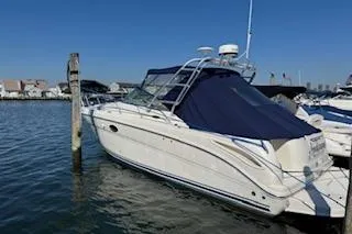 The Image of 2007 Sea Ray 270 Amberjack boat docked in a marina under clear blue skies. - 0