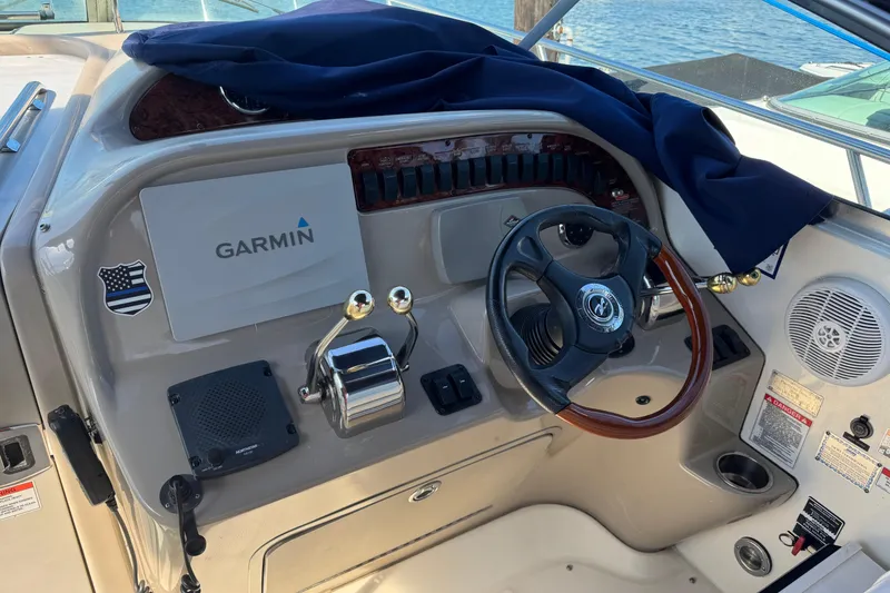 Slide: The Image of 2007 Sea Ray 290 Amberjack boat docked in marina, featuring blue canopy and sleek design. - 1