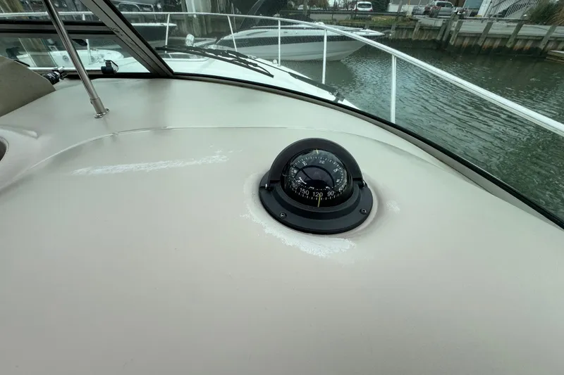 Slide: The Image of Compass on 2007 Sea Ray 290 Amberjack boat dashboard, docked by water. - 16