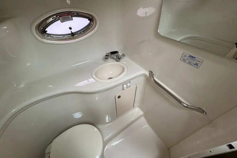 Slide: The Image of 2007 Sea Ray 290 Amberjack bathroom with sink, toilet, and porthole window. - 25