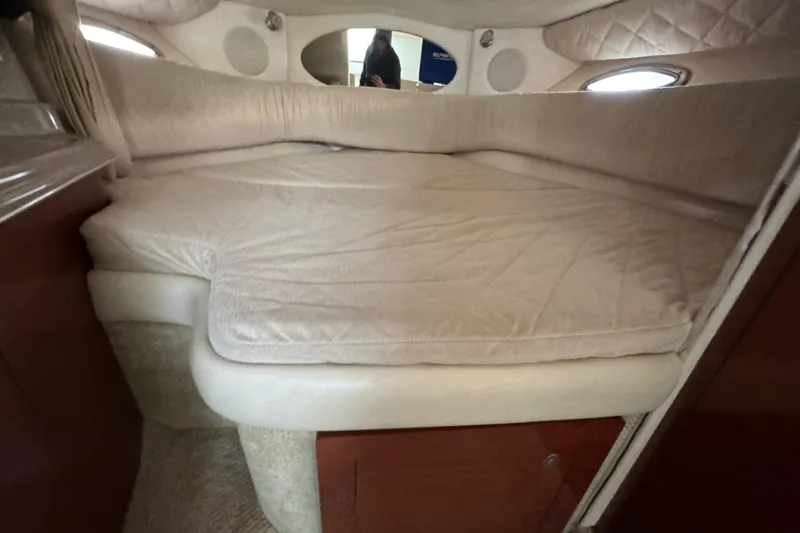 Slide: The Image of 2007 Sea Ray 290 Amberjack cabin interior with beige bedding and wood accents. - 28